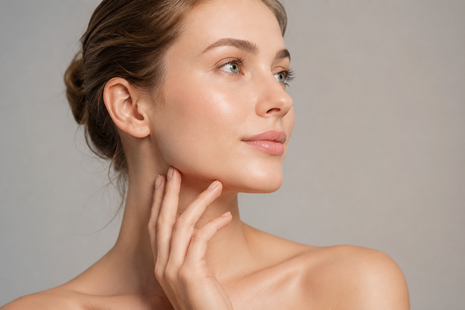 Woman touching jawline representing facial sagging treatment and skin tightening options
